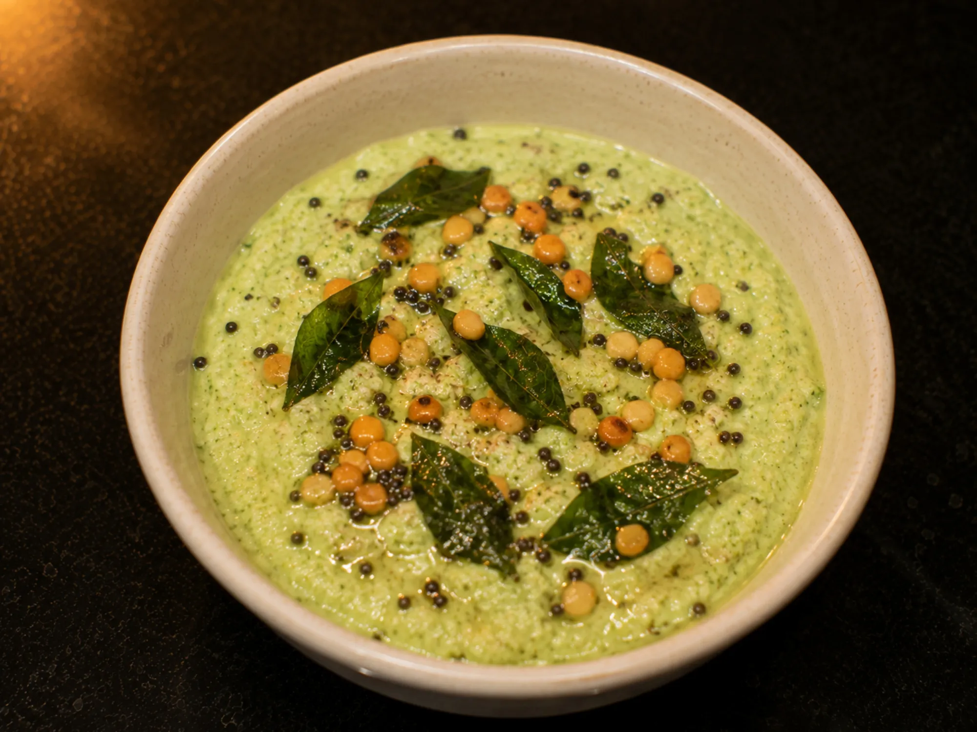 A pale green ridge gourd chutney in a small bowl with a mustard seed tempering