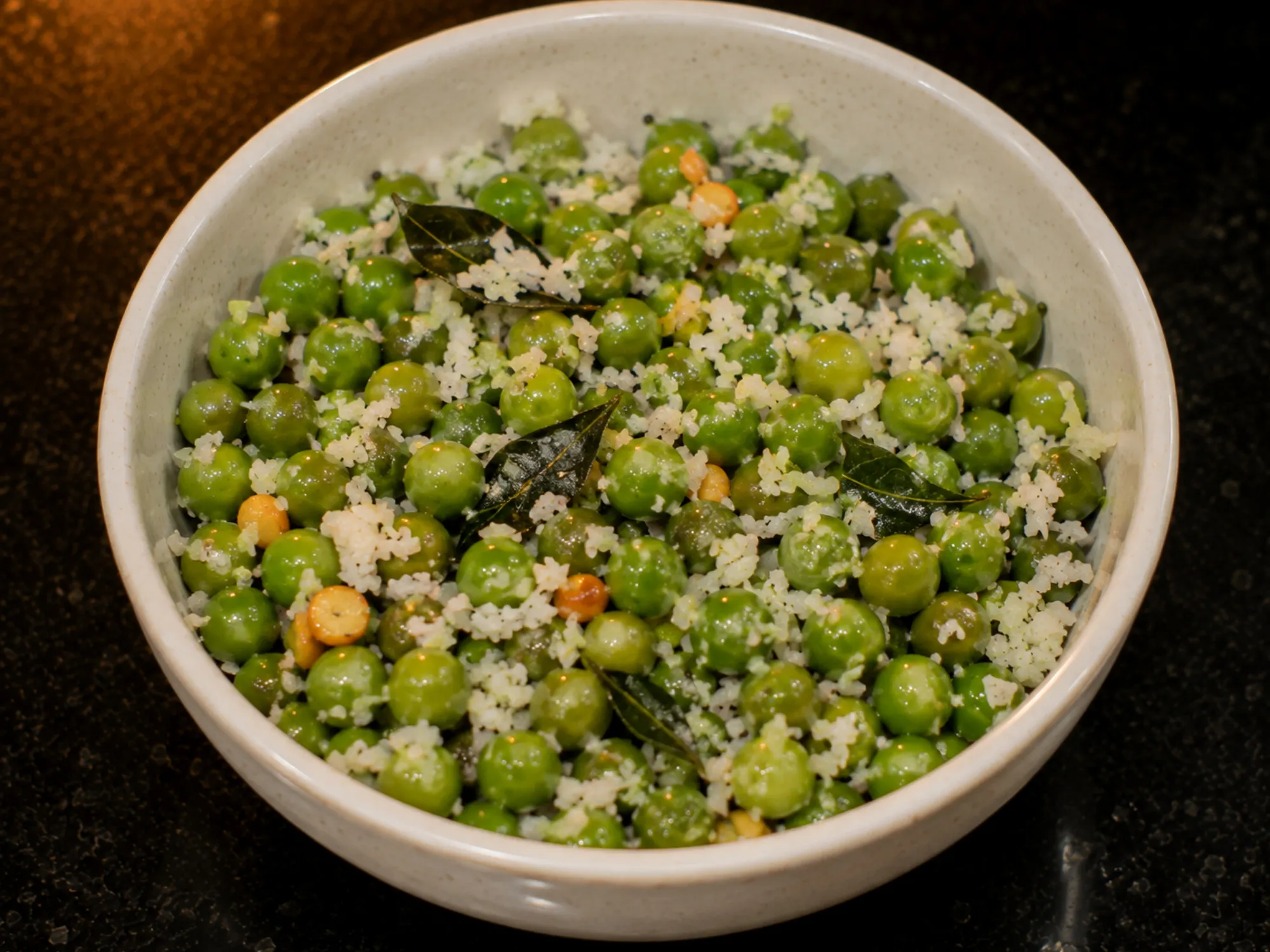 Bright green peas tossed with grated coconut and curry leaves in a steel bowl